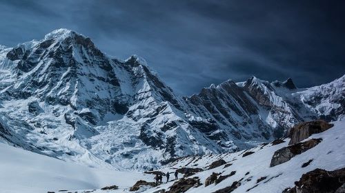 Snowed mountains with people walking far away